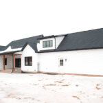 front view of new home construction with white siding and gray roof