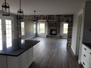 open floor plan with kitchen leading to the living room with a stone arch