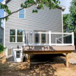 home addition and remodel with new gray vinyl siding and wooden deck