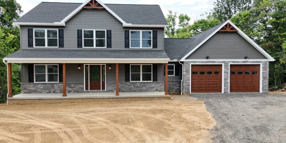 front view of a new construction home with a two car garage, front porch, and two stories