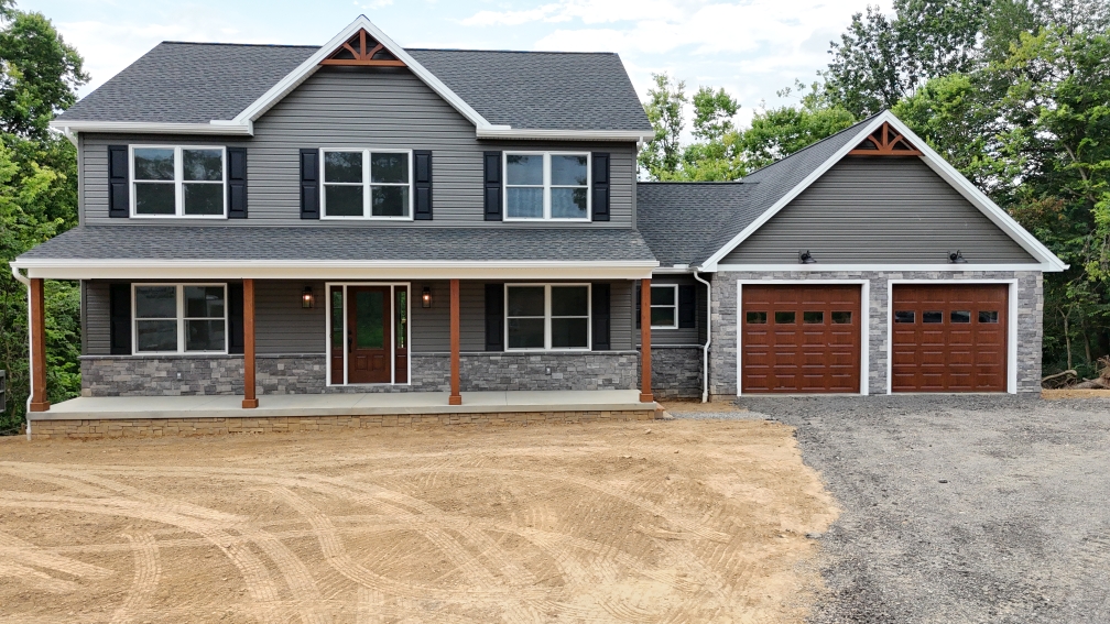 front view of a new construction home with a two car garage, front porch, and two stories