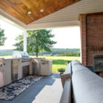 new outdoor kitchen with sink, grill, mini fridge, and fireplace