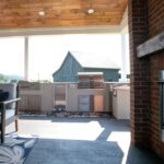 outdoor kitchen, couch, and fireplace under a covered outdoor living space