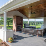 covered porch addition with outdoor kitchen, fireplace, seating area, and hot tub