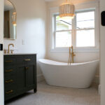 bathroom addition with green sink and tub