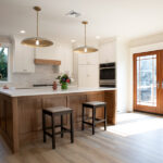 kitchen remodel with hardwood floors, wooden island, and double doors leading to deck