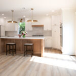 kitchen remodel with hardwood floors, wooden island, white cabinets, and double doors leading to deck