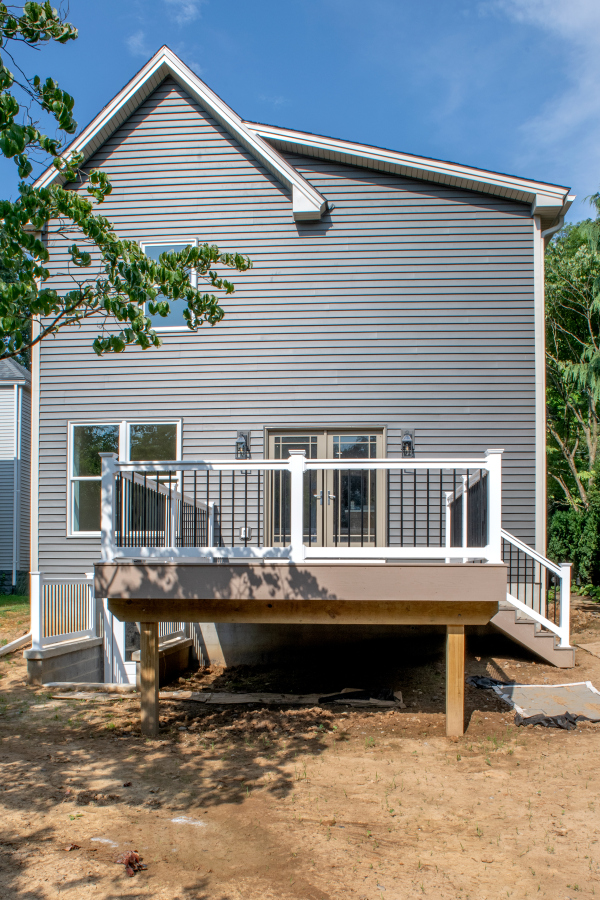 back view of a remodeled home with new siding and deck