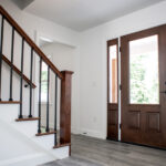 wooden front door to wooden stairwell in new home