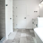 new bathroom with white walls, tub, shower, and separate room for toilet