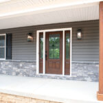 front porch of a new home with wooden door and pillars