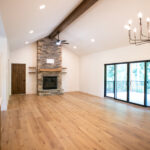 new living room off of the kitchen with a fireplace and doors to the deck
