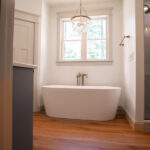 bathroom in a new home with blue cabinets and bathtub