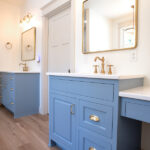 double sink in a new bathroom with blue cabinets