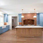 kitchen with blue cabinets and brick details around stove
