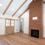 new living room with hardwood floors and brick fireplace