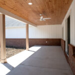 back porch with beams and ceiling fan for a new home