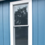 new blue siding and white windows on home renovation