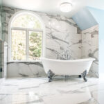 bathroom renovation with claw foot tub and marble walls and floors