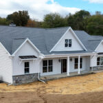front left view of a new home with white siding and stone details
