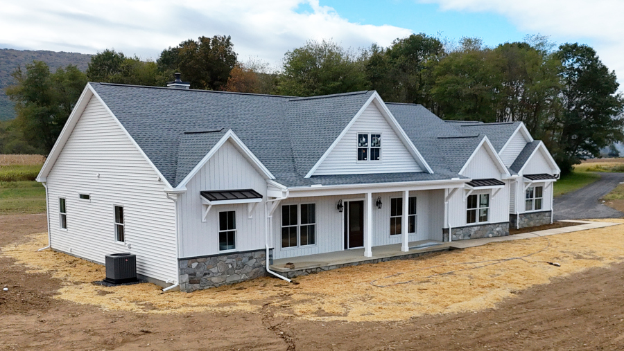 front left view of a new home with white siding and stone details