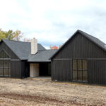rear view of a new home with black siding