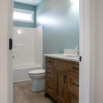 shower, toilet, and sink in a new bathroom with blue and white walls
