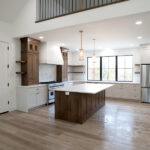 new kitchen with wood floors, island, and white counters