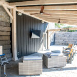 seating, TV, and ceiling fans on a covered back porch