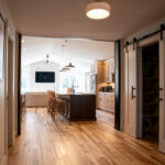 hallway to a kitchen with an island and living room with a TV