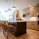 kitchen after a home renovation with an island, two ovens, and light wood cabinets
