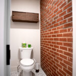 toilet room with brick wall