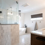 renovated bathroom with a modern sink, bathtub, and shower