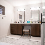 double sinks with vanity stool, rectangle mirrors, and dark brown cabinets