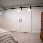 large white double barn doors in renovated bedroom