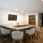 bar area with modern countertop, sink, TV, and comfortable bar stools