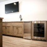 bar area with mini fridge, sink, and TV