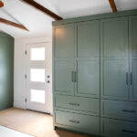 renovated mudroom with large green storage cabinets