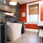 new bathroom with red and black walls, with a modern tub, sink, and shower