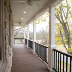 front porch with ceiling fans, hardwood decking, and black railings
