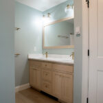 double sink with a large mirror and sconces in a new master suite