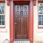 new front door made with brown hardwood with red trim