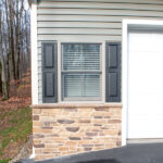 close up of green siding and stone details of a siding remodel
