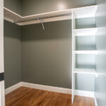 new closet with shelves, hardwood floor, and green walls