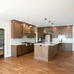 new kitchen with hardwood floors and cabinets, white counter top, and island