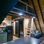 remodeled cabin interior with new kitchen, barn doors, and loft