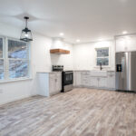 new kitchen with white cabinets and stainless steel appliances