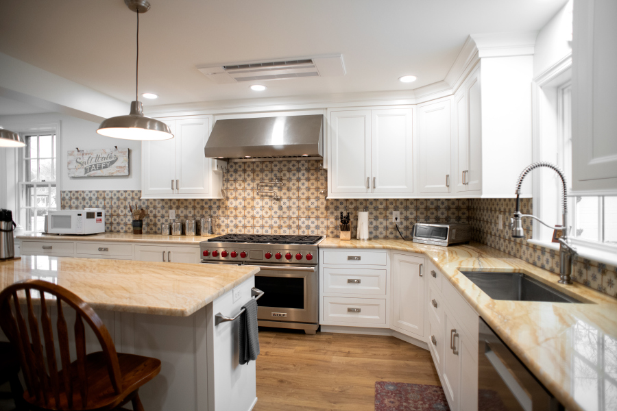 kitchen addition with white cabinets, wooden counters, tile backsplash, and island