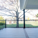 new deck with TimberTech flooring, roof with vinyl ceiling, and black railings
