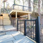 stone pathway with a gate and cable railings to a deck